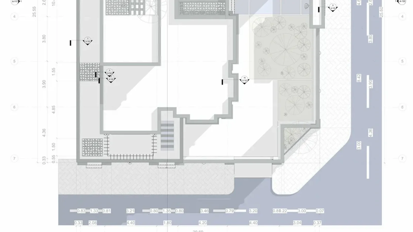 Architectural site plan of a corner villa: the building footprint with its courtyards and planting, paved walks and the two streets around the lot, with dimension strings along the road